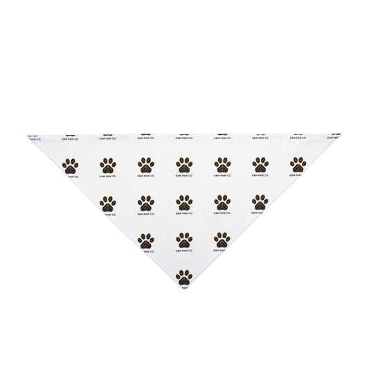 White pet bandana with black and gold paw print pattern and K&M Paw Co. logo, designed for dogs and cats as a stylish, high-quality accessory for US pet owners